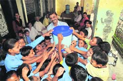 Schoolchildren receive a water filter sponsored by UCOST. 