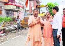 A saint pleads to the ADM to stop a demolition drive at an ashram at Devpura in Haridwar on Thursday.