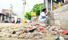 A man looks at the demolished extention near the Chandigarh road in Ludhiana 