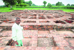 Teja Singh, an ASI attendant, points at a Buddhist Stupa at Sanghol 