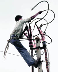 An electrician risks his life as he repairs wire atop an electricity pole by tying himself with the rope in Sector 16, Chandigarh.