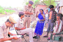 Policemen conduct a verification drive at the Malin Basti in Dehradun on Friday.