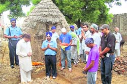 UK-based Surinder Singh Nijjer with flood-hit farmers at Samana in Patiala on Friday.