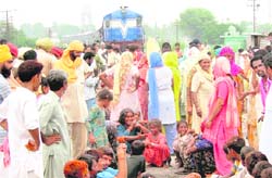Residents of the Bangi Nagar area stop a train to demand the draining out of water from their area. 