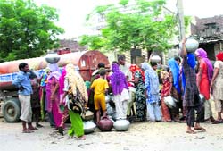 Residents stand in a queue to get potable water from a tanker at Bahu Akbarpur village, 10 km from Rohtak, on Saturday