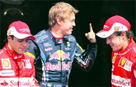 Red Bull Formula One driver Sebastian Vettel stands between second placed Ferraris Fernando Alonso (R) and third placed Ferraris Felipe Massa following the qualifying session for the German Grand Prix at the Hockenheim circuit on Saturday