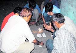 Labourers gamble at the Prince Chowk in Dehradun on Sunday