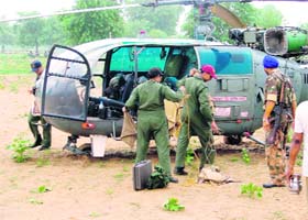 Pilots cover vital parts of a chopper after an emergency landing near Chindhar village in Fatehabad