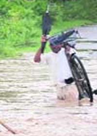 A man wades through a flooded area in Chhachharuli