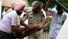 Jail superintendent SS Saggu (in civvies) is also seen in the picture; an undertrial, who fainted during the protest, being taken to a hospital.