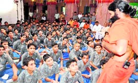 Yoga guru Ramdev interacts with students of Shiv Dale Public School in Haridwar during the shooting of his film on Monday.