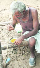 A flood victim eats food provided by the authorities at Baloli.
