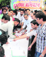BJP workers during a signature campaign in Faridabad on Monday.