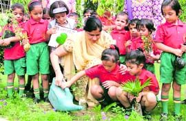 Tiny tots of Green Land Senior Secondary School plant saplings on the school campus in Ludhiana on Monday