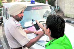 A youth forcing a cop to talk on his mobile phone during a challan drive in Ludhiana