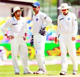Sachin Tendulkar talks to MS Dhoni as Virender Sehwag (L-R) walks by on the first day of the second Test in Colombo on Monday. 