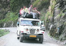 In the absence of any alternative mode of transport, commuters take a ride on top of a jeep near Nainital on Tuesday. 