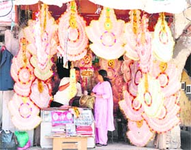 A shopkeeper sells garlands made of currency notes at the Canal road market in Jammu. 