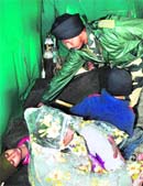 A BSF medical staffer gives first aid to a pilgrim who fainted due to less oxygen at Maha Ganesh top en route to the Amarnath cave shrine