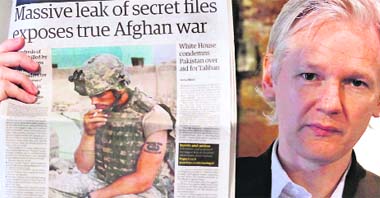 WikiLeaks founder Julian Assange holds up a copy of a newspaper during a press conference in London on Monday.