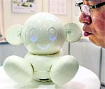 A man talks to Raytron's communication robot "Chapit" during Robotech, an exhibition on service robot manufacturing technologies, in Tokyo on Wednesday. With only speech commands, it can control home electronics facilities