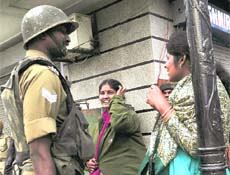 A jawan talks to Amarnath yatris, who were stranded at Lal Chowk in Srinagar due to a bandh on Wednesday.