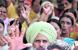A member of the Punjab Subordinate Services Federation, Ludhiana, raises his hand during a protest in Ludhiana on Wednesday.