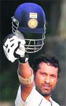Sachin Tendulkar raises his helmet after completing his century on Wednesday.