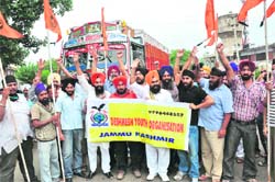 Members of the Sikh community block the Jammu-Pathankot National Highway near Digiana Ashram in Jammu on Thursday.