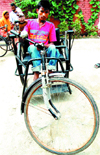 A physically challenged youth rides a tricycle having rusty wheel rims at the DDRC Centre in Amritsar.