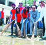 Employees of Big FM and Improvement Trust Chairman Sanjiv Khanna clean a road in Ranjit Avenue in Amritsar.
