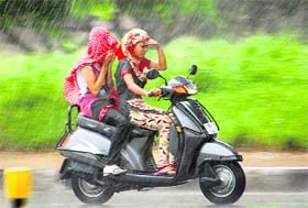 Two girls caught unawares as heavy showers lashed the city on Friday evening, providing residents the much-needed respite from sultry conditions. The mercury recorded a maximum 35 °C and a minimum of 26.9 °C.