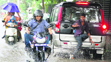 Vehicles pass through rainwater in Dehradun