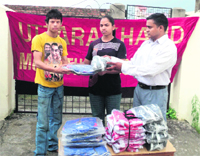 Uttarakhand Muai Thai players being given tracksuits at a function in Dehradun