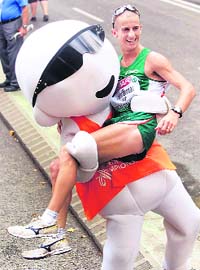 Robert Heffernan from Ireland poses with the official mascot Barni after the mens 50 km walk at the European Athletics Championships in Barcelona