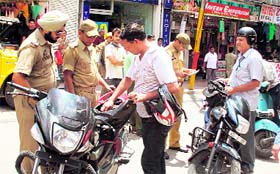 Policemen check papers and vehicles at the City Chowk in Jammu on Saturday.
