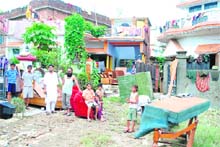 Residents of Morowala with their household goods damaged in rain water on Sunday. 