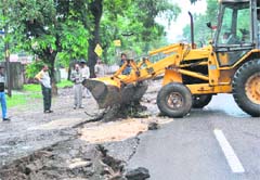 A bulldozer fills a chasm in a road at Vasant Vihar in Dehradun on Saturday. 