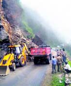 Workers clear the Shimla-Solan road that was blocked following a rockslide on Sunday.