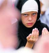 A Bosnian Muslim girl prays at Lastavica mountain on Sunday. The tradition of praying for good harvest on the mountain began more than 600 years ago when the Turks brought Islam to the region. 