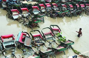 Cyclerickshaws submerged in water as the Yamuna level rises in New Delhi on Monday.