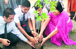 Students and staff of Touchwood School plant saplings with a member of iCARE on Monday.