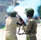 A policeman fires tear-gas shells to disperse protesters in Srinagar on Monday. 