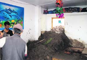 Residents remove debris from a house at Landour Cantt Board