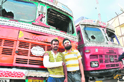 Injured drivers in front of their damaged trucks near the railway station in Jammu