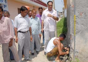 A worker severs a water supply connection at a residence