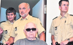 Nazi death camp guard John Demjanjuk arrives in a courtroom in Munich on Tuesday. The former Ohio autoworker is being tried on nearly 28,000 counts of accessory to murder over allegations that he was a guard at the Nazis' Sobibor death camp