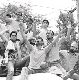 Sitting on the roof of a bus, protesters in Khrew raise slogans against recent killings in Pampore in Pulwama district on Wednesday