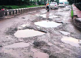 The potholed road on the Gurthali bridge