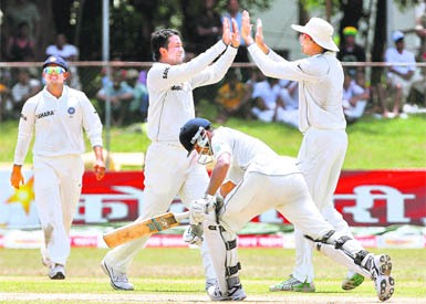 Pragyan Ojha (2nd L) celebrates the wicket of Prasanna Jayawardene with VVS Laxman (R) as Suresh Raina (L) walks in Colombo on Wednesday.